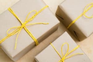 handmade craft presents. paper wrapped gifts with yellow twine bows. assortment of festive packages on light background.